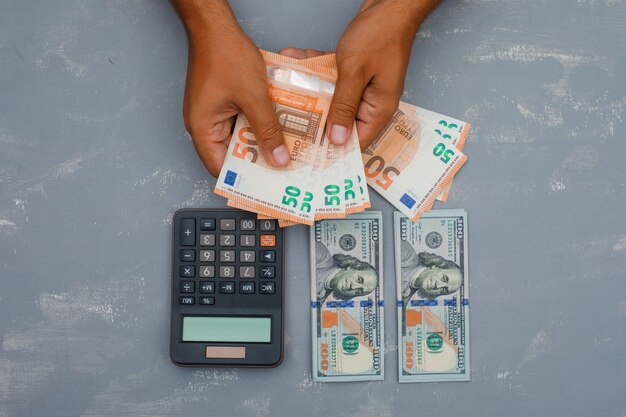 calculator on plaster table and man counting money.