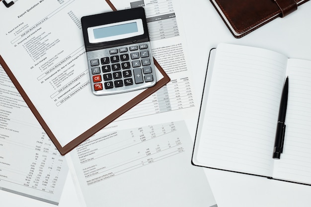 Calculator on several documents and a notebook