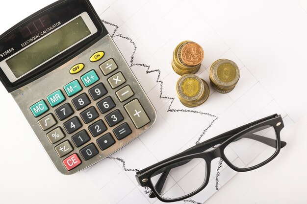 Calculator with coins on table