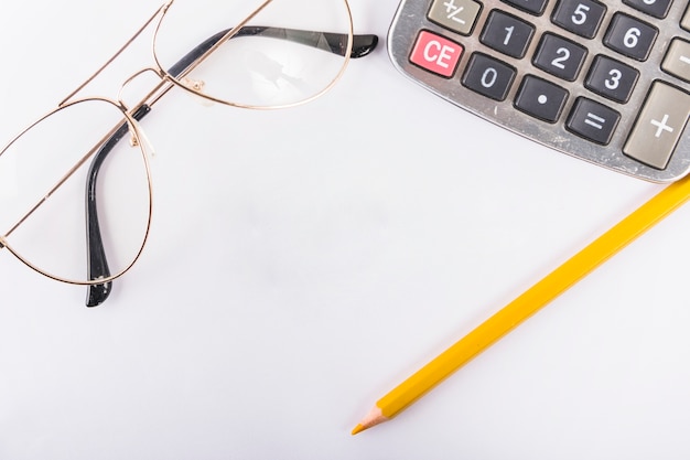 Calculator with glasses on table