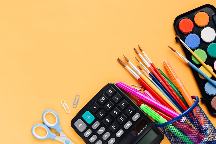 Free Photo calculator with scissors and drawing tools scattered on yellow desk