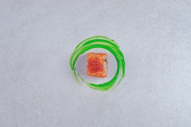 California sushi roll on white background with green plastic ring.