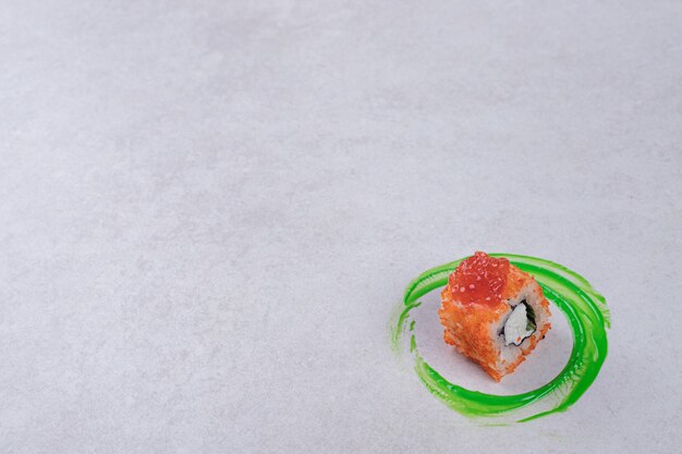 California sushi roll on white background with green plastic ring.