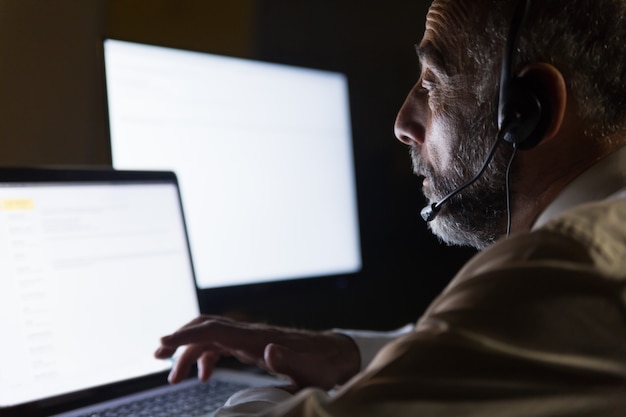 Call center worker in headset using laptop