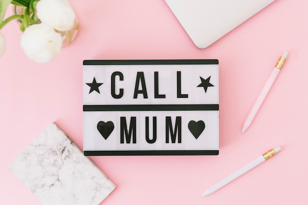 Free photo call mum inscription with white flowers and laptop