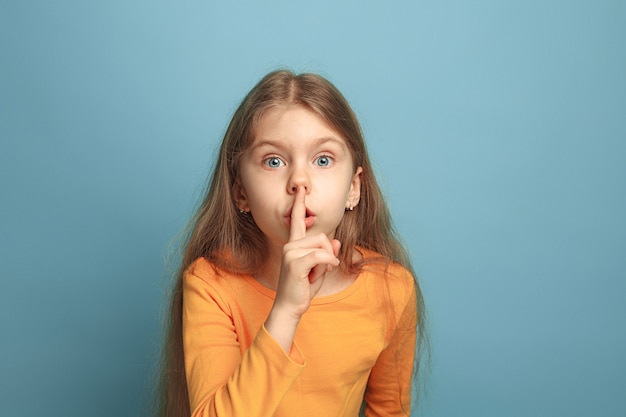 The call for silence. Teen girl on a blue. Facial expressions and people emotions concept