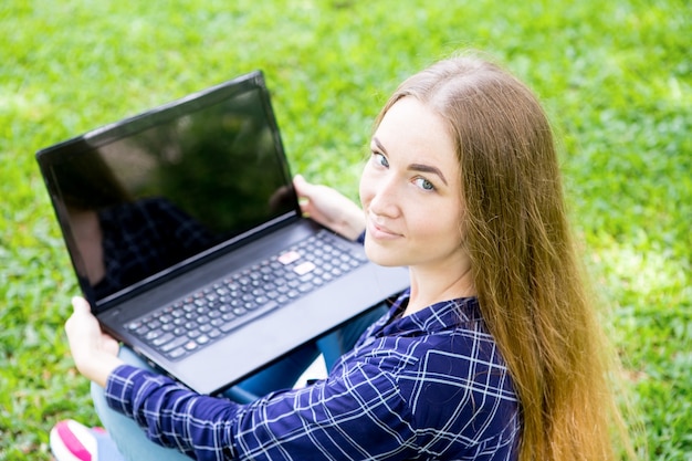 Calm attractive woman working on laptop in park