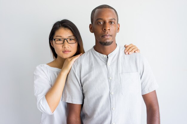 Calm beautiful young interracial couple looking at camera. 