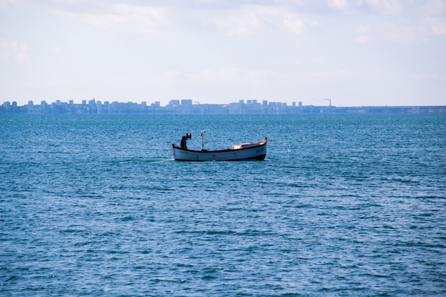 Calm ocean with a boat under cloudy skies