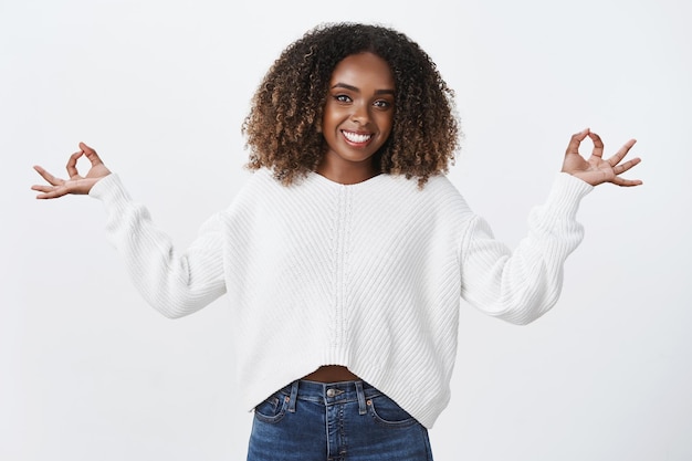 Calm peaceful african-american attractive happy woman smiling relieved emotions under control meditating