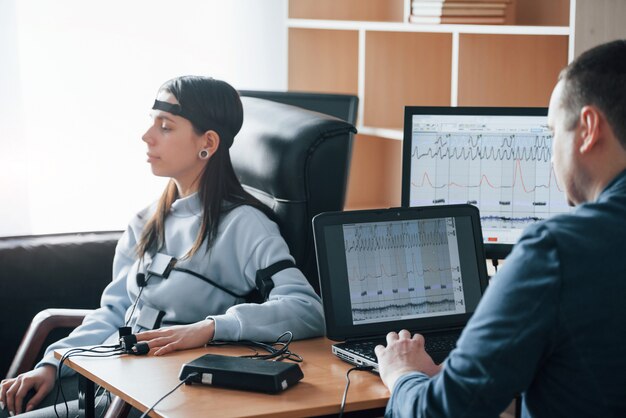 Calm woman. Girl passes lie detector in the office. Asking questions. Polygraph test