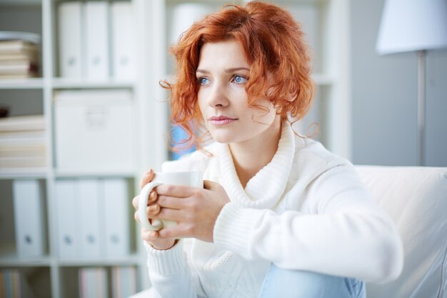 ホットドリンクを持つ穏やかな女