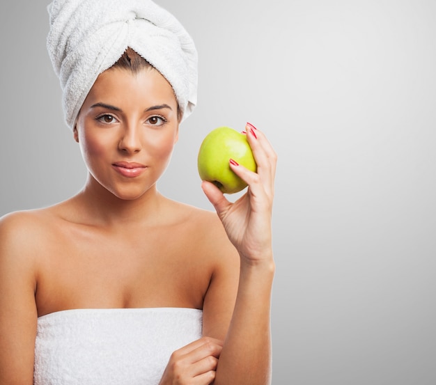 Calm woman with towel on head and apple in hand