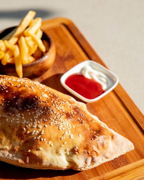 Foto gratuita pizza calzone con patatine fritte e ketchup