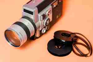 Free photo camcorder with filmstrip on peach colored backdrop