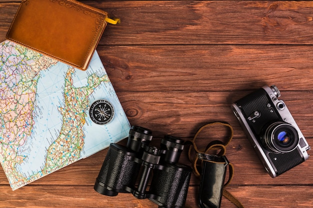 Камера и бинокль с компасом на карте и дневнике