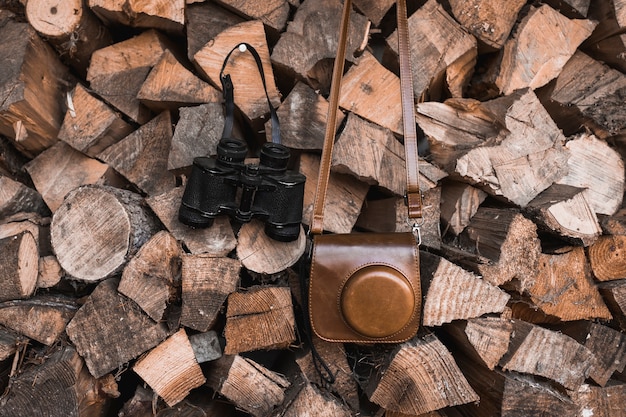 Camera and binoculars on firewood