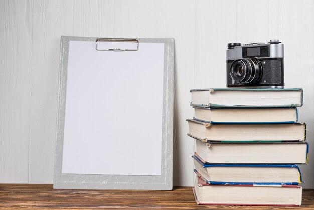 Camera and books near clipboard