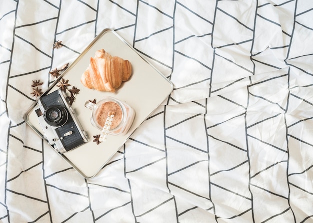 Camera and breakfast food on bed