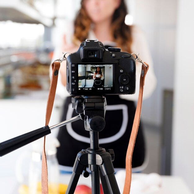 Camera filming woman in kitchen