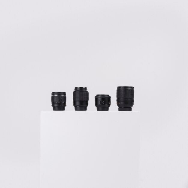 Camera lenses arranged on white block against isolated on white background