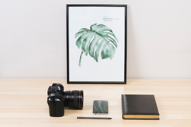 Camera with smartphone and notebook on table