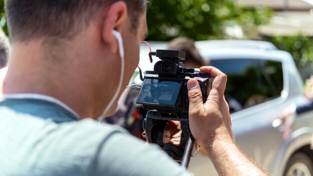 삼각대에 카메라를 사용하여 결혼식을 촬영하는 카메라맨