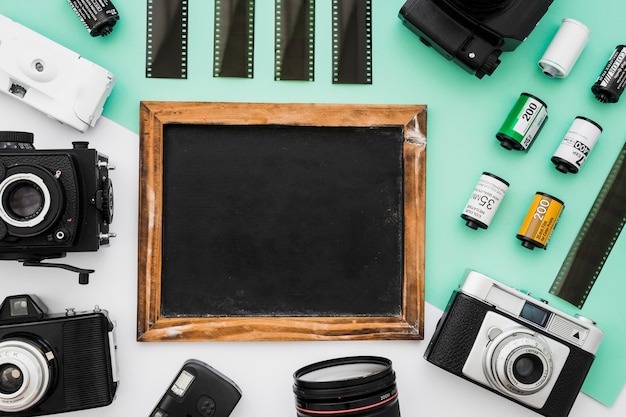 Free photo cameras and film lying around chalkboard