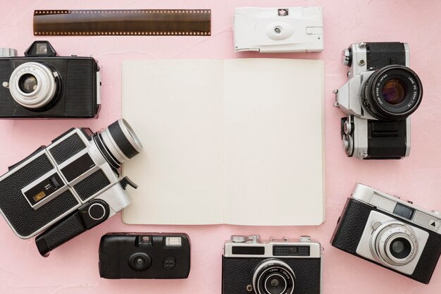 Cameras and film strip around notebook