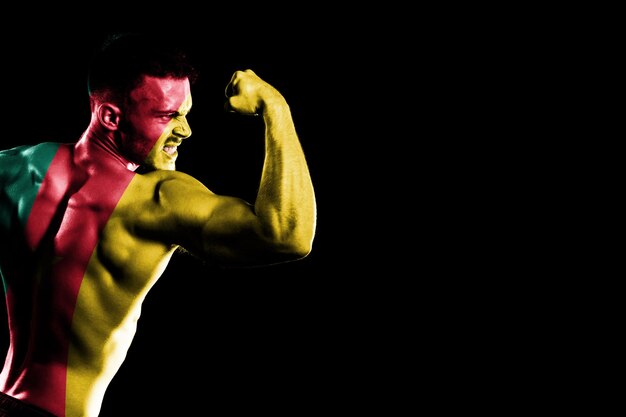 Cameroon flag on handsome young muscular man black background