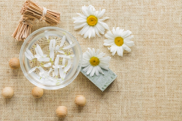 Camomiles and glass with camomile petals