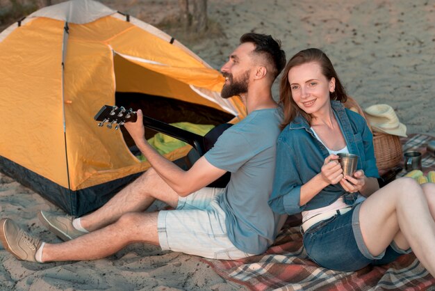 Camping couple back to back looking away