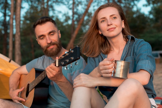 Free photo camping couple enjoying the music