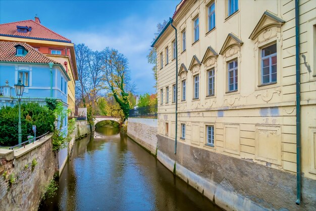 チェコ、プラハ、マラーストラナのレノンの壁近くの建物の間を流れる運河