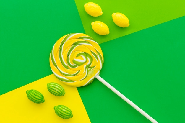 Candies and lollipop on contract colored paper background