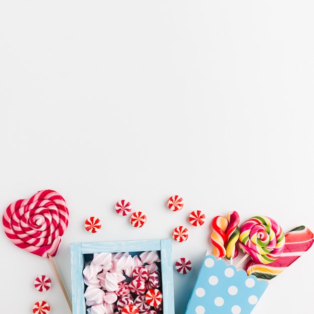 Candies and lollipops on white table with copy space