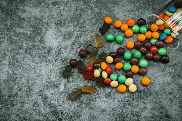 Candies and marmalade scattered on table