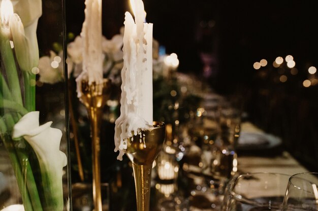 Candle in golden candlestick on wedding table