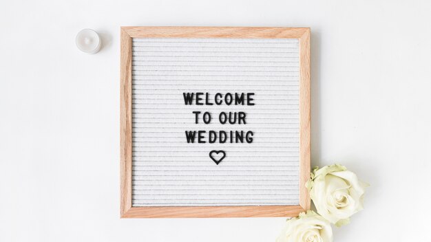 Candle and rose with welcome frame for wedding on white backdrop