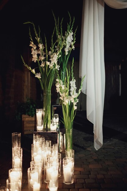 Candles burn standing in tall vases on the floor
