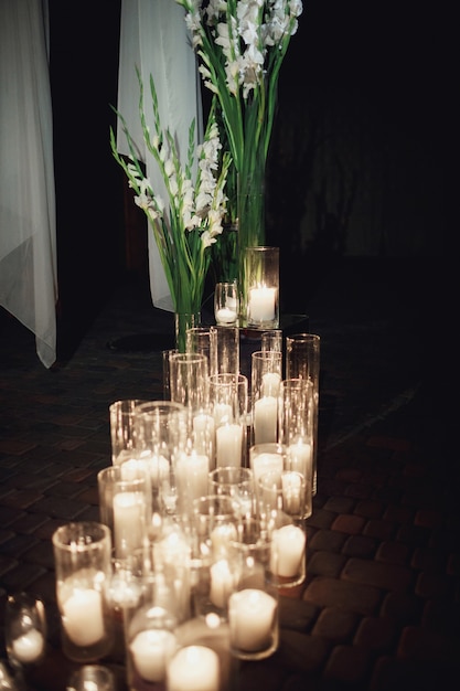 Candles burn standing in tall vases on the floor