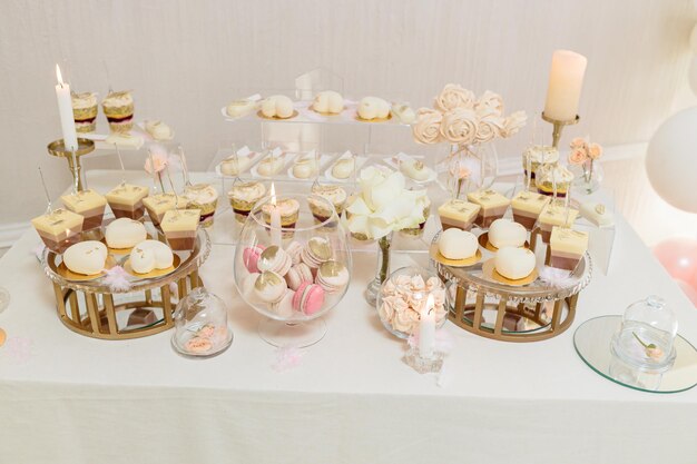 캔디 바와 웨딩 케이크. 과자가 있는 테이블, 컵케이크가 있는 뷔페, 사탕, 디저트.