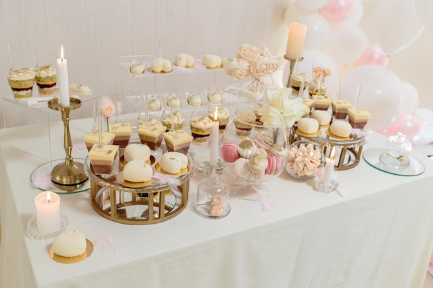 캔디 바와 웨딩 케이크. 과자가 있는 테이블, 컵케이크가 있는 뷔페, 사탕, 디저트. 프리미엄 사진