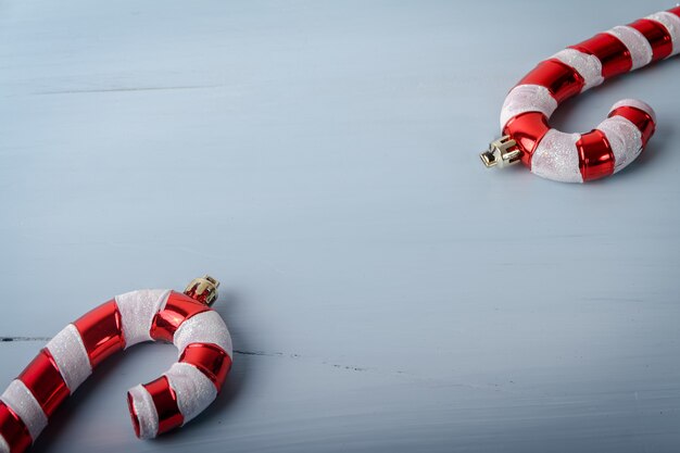 Candy cane shaped Christmas toys on a white cracked wooden surface with a copy space