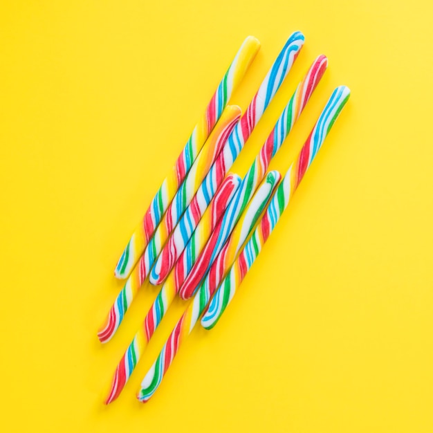 Free photo candy canes on yellow backgound