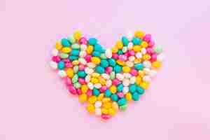 Free photo candy colourful heart on pink table