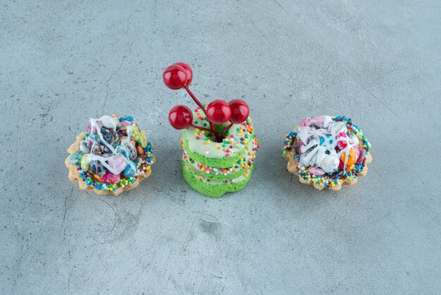 Candy cupcakes and small donuts on marble background. High quality photo