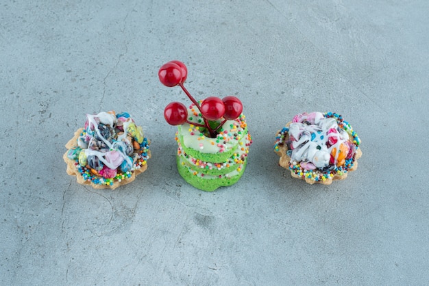Кексы и маленькие пончики на мраморном фоне. Фото высокого качества