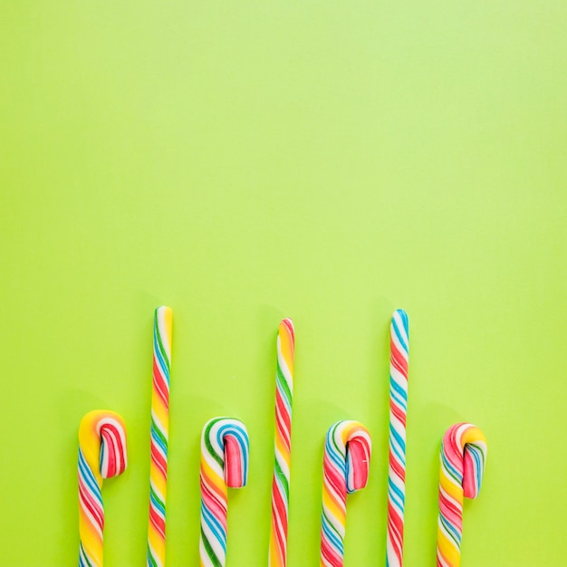 Candy sticks on green background