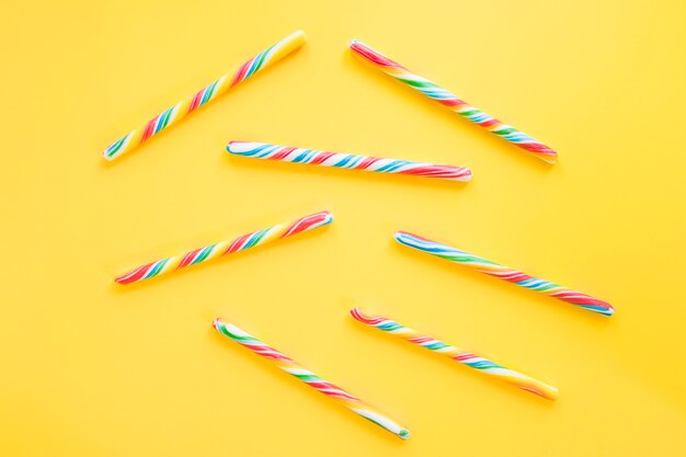 Candy sticks on yellow table